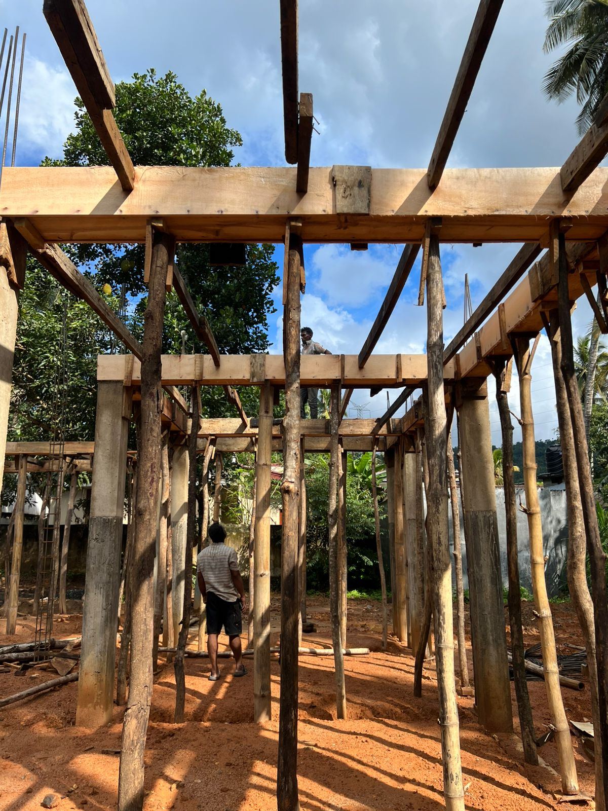 Timber framework for a small building beside a clear blue sky